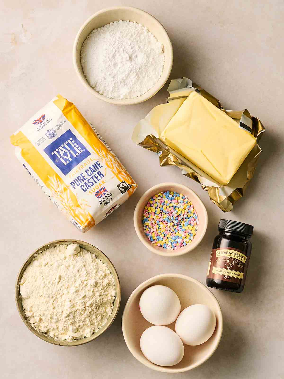 The ingredients for making Vanilla Cupcakes laid out on a white counter.