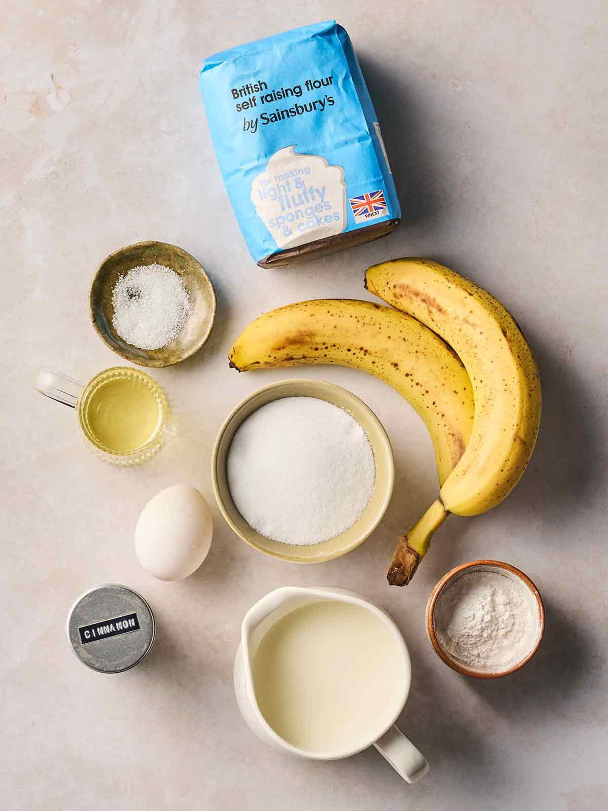 The ingredients for making Banana Pancakes laid out on a white counter top.