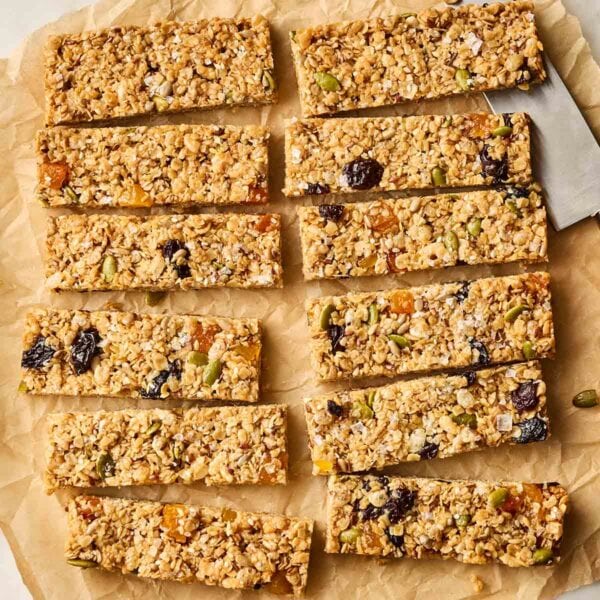 A bath of 12 cut granola bars on a baking paper sheet.