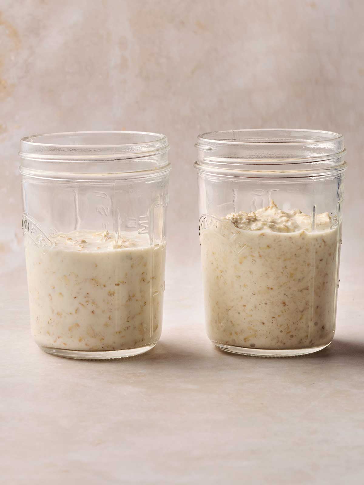 Two mason jars side by side, the right hand one is before soaking oats in milk and yoghurt overnight, the left hand side one is after being soaked, so its contents are larger.