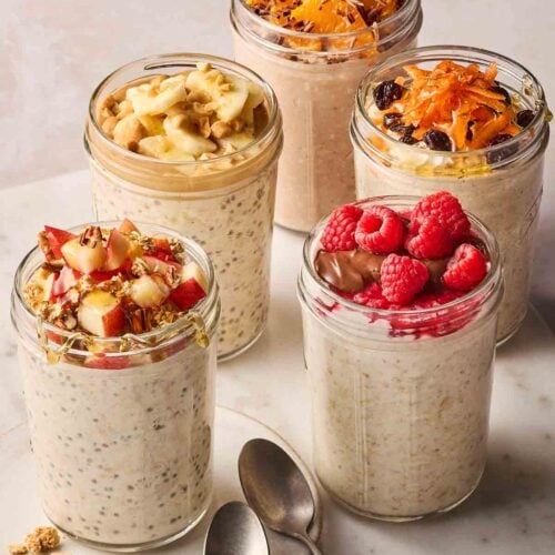 Five jars of overnight oats, ready to eat, with lots of topping styles.