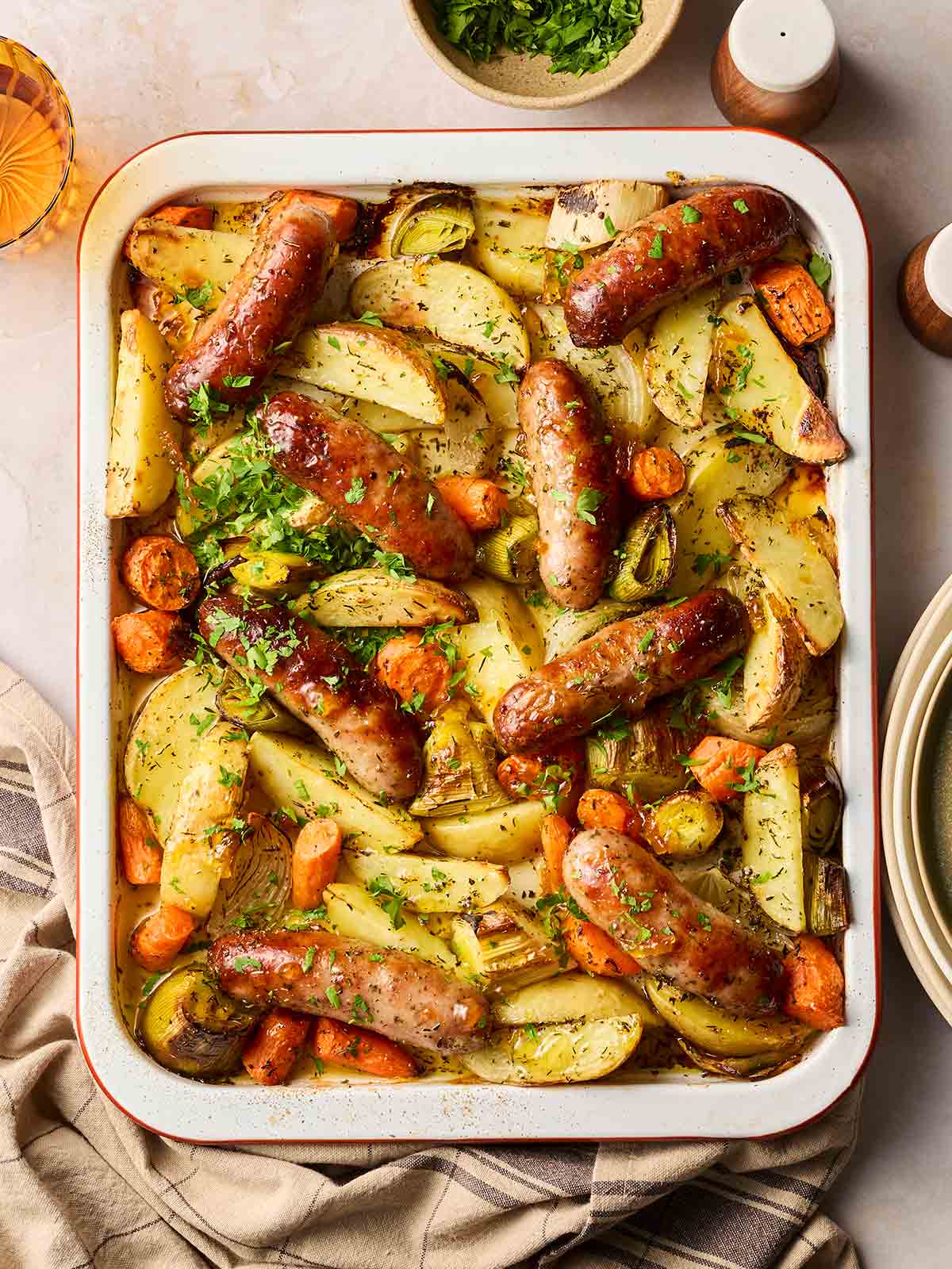 Sticky sausage tray bake on a table, ready to serve.