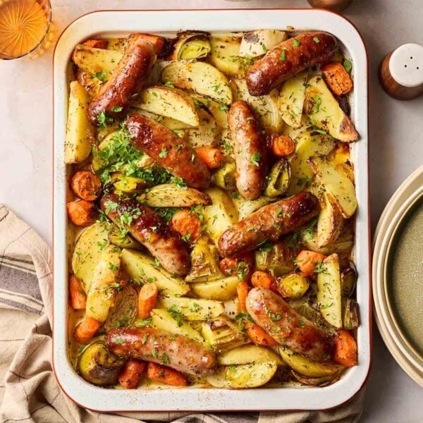 Simple sausage tray bake with carrots potatoes and leeks, all on one tray.