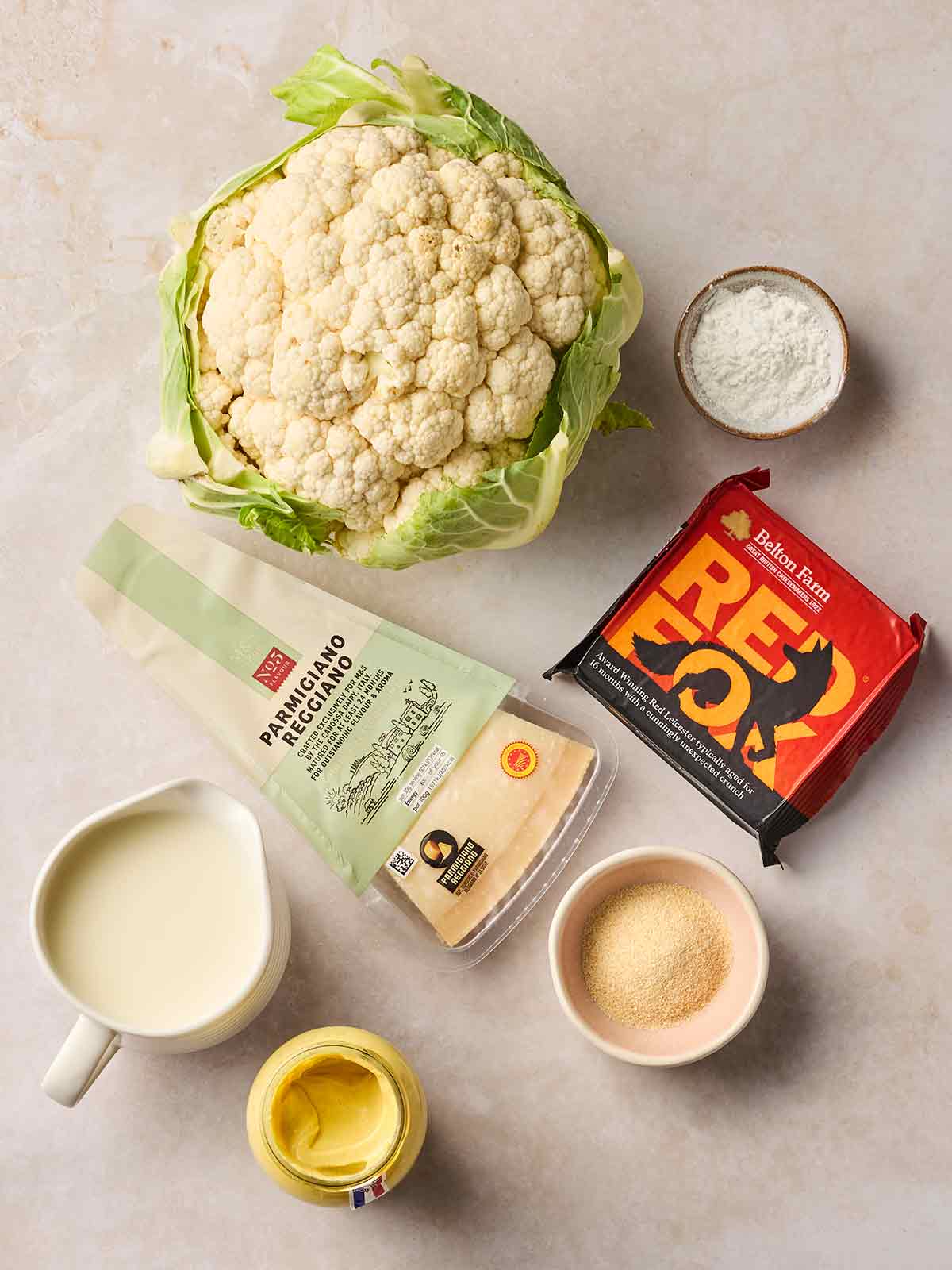 Cauliflower Cheese recipe ingredients laid out on a white counter.