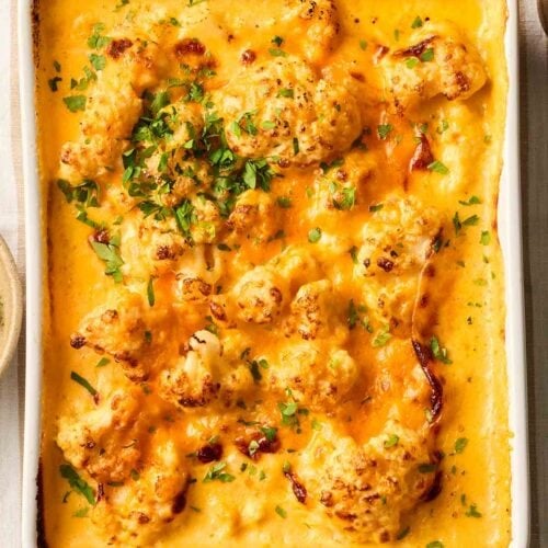 A table with an oven dish on, with baked Cauliflower Cheese ready to serve.