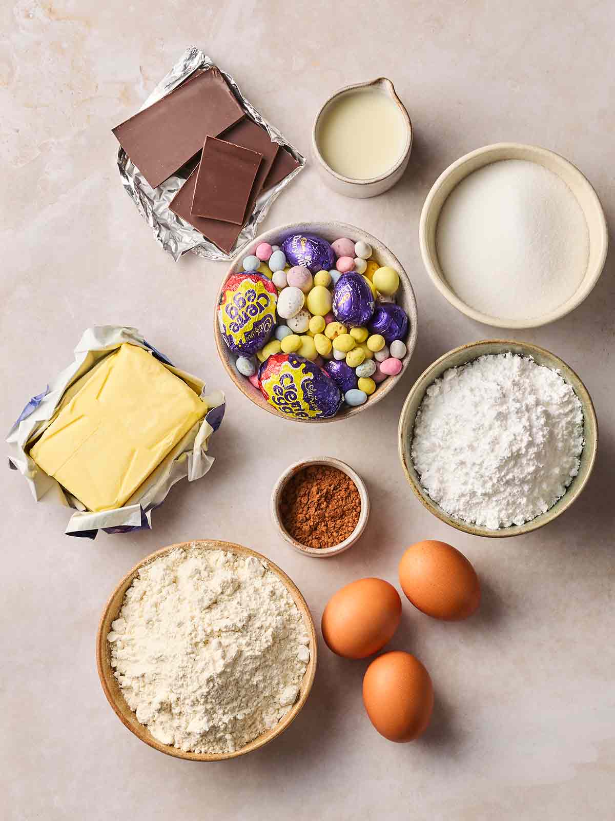 The ingredients for making an Easter Chocolate Cake laid out on a white surface.