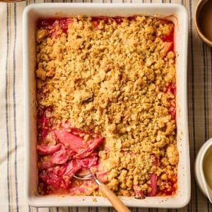 A classic rhubarb crumble in an oven dish, with bright pink rhubarb and a golden, baked topping.