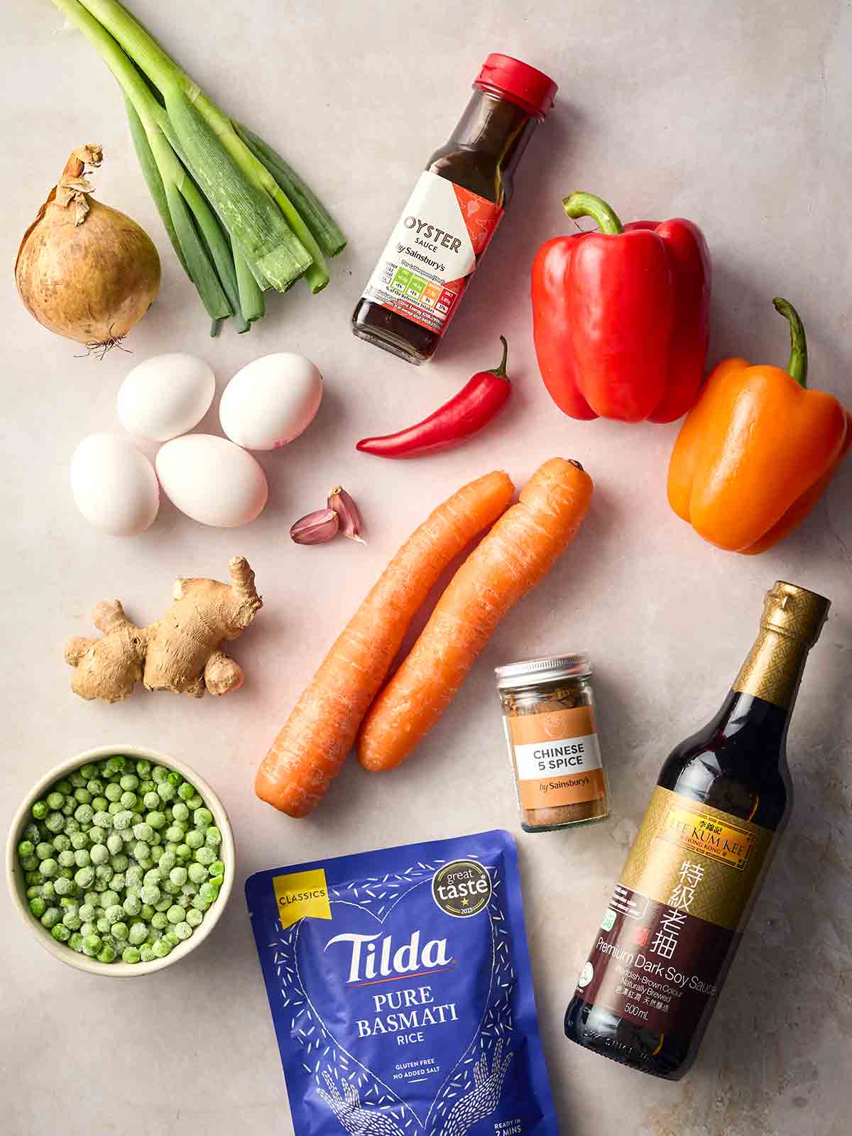 The raw ingredients for making Egg Fried Rice laid out on a white counter.