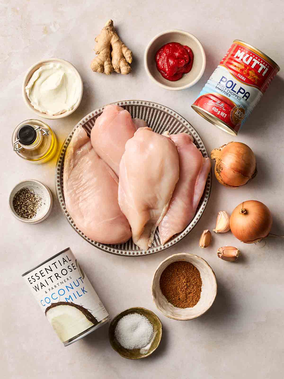 The ingredients for making easy chicken curry laid out on a white counter top.