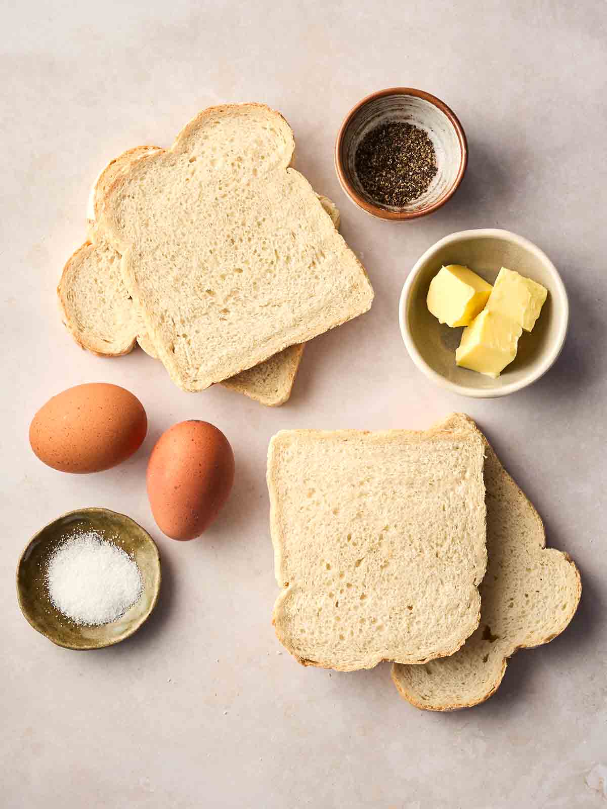 The ingredients for making Eggy Bread laid out on a white counter top.