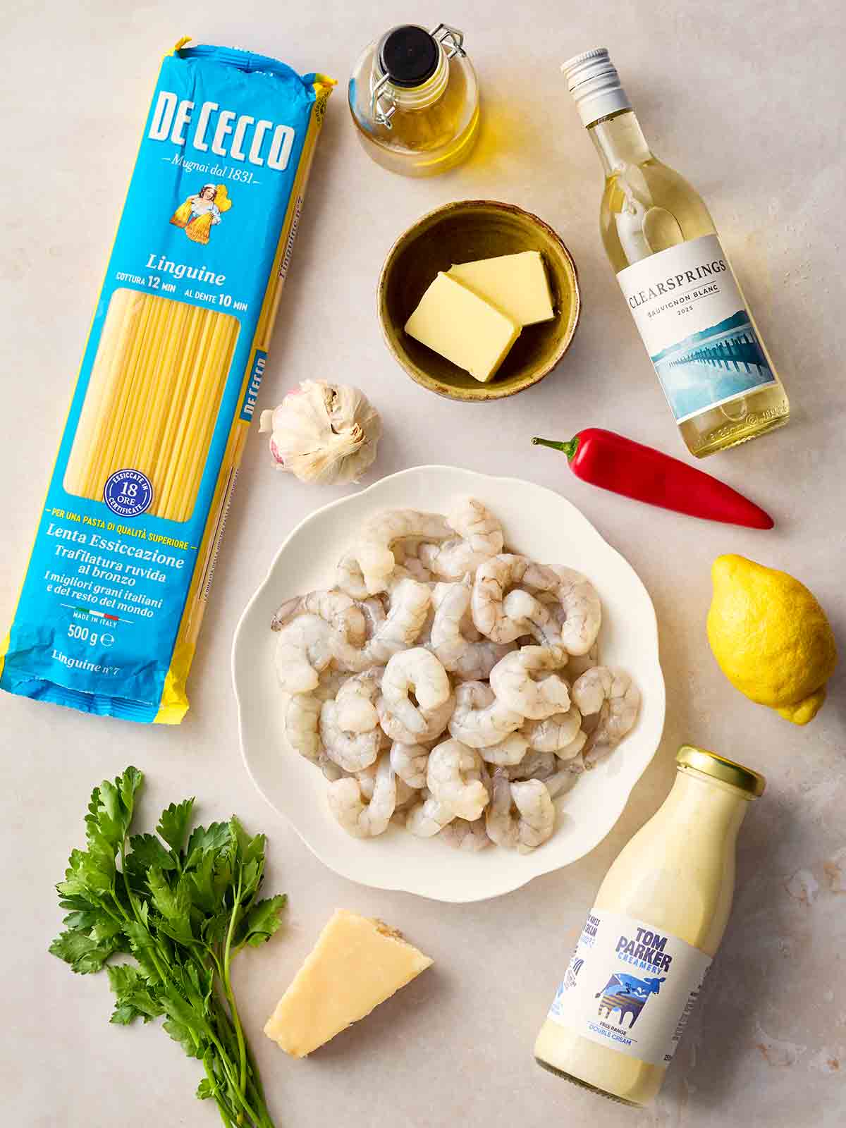 The ingredients for making prawn linguine laid out on a white surface.