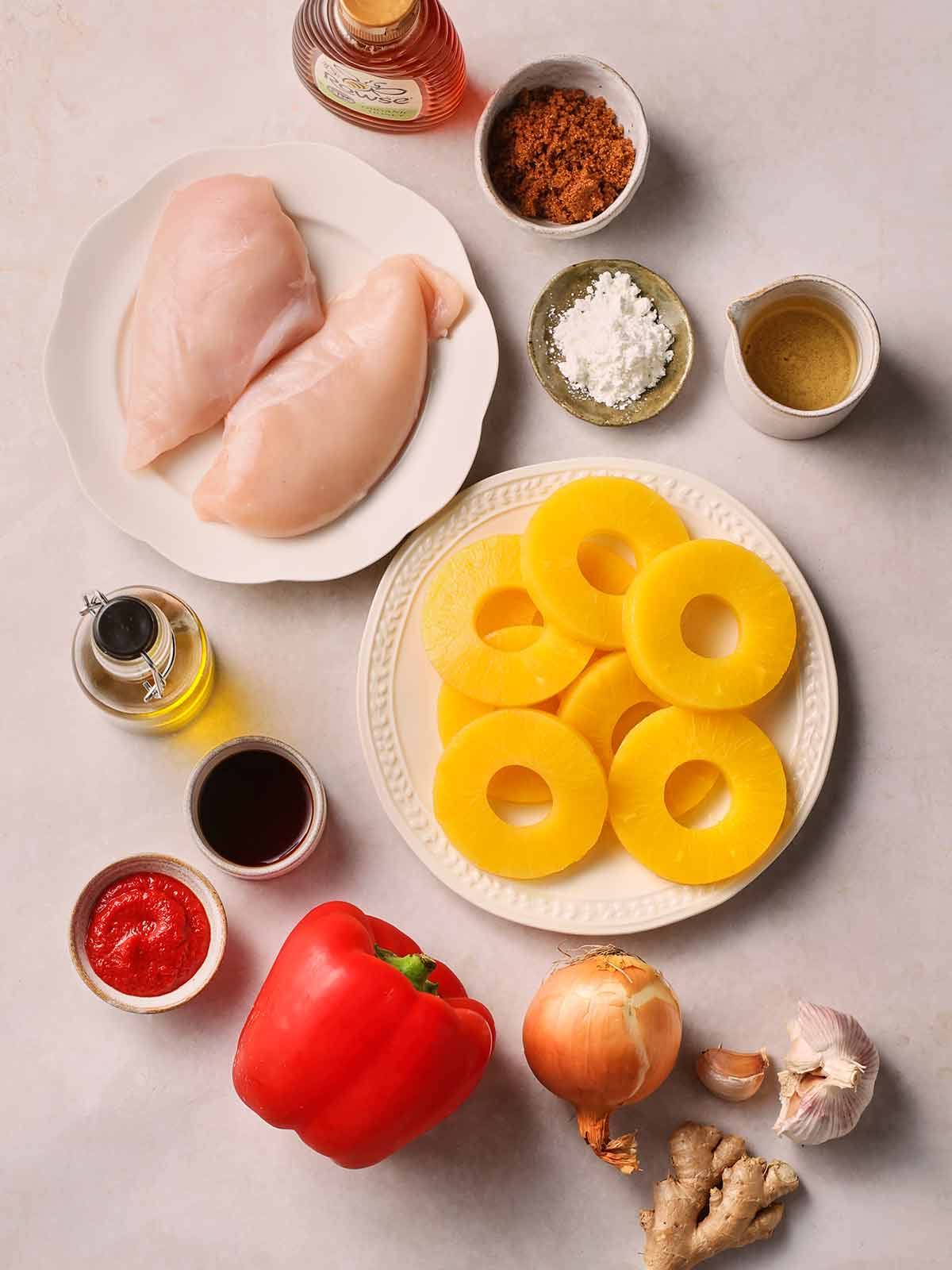 The ingredient for making Sweet and Sour Chicken laid out on a white surface.
