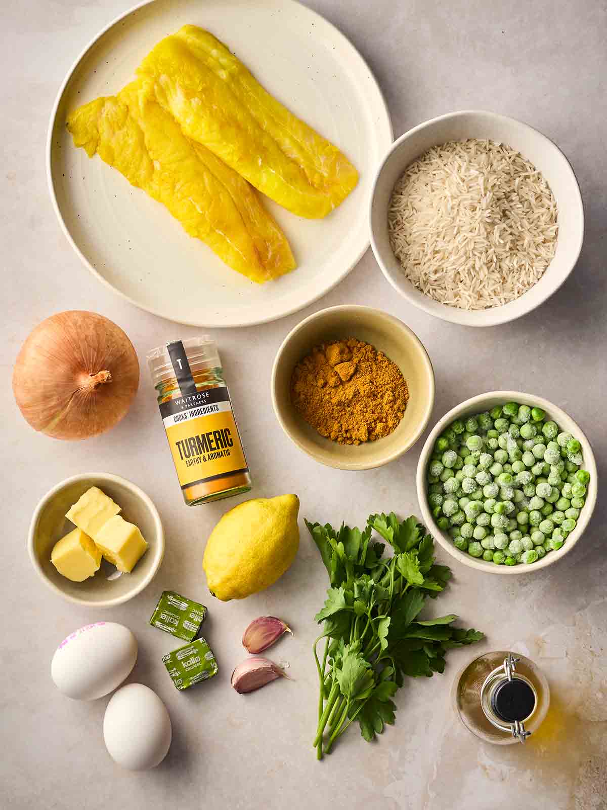 The ingredients for making Kedgeree laid out on a white surface.