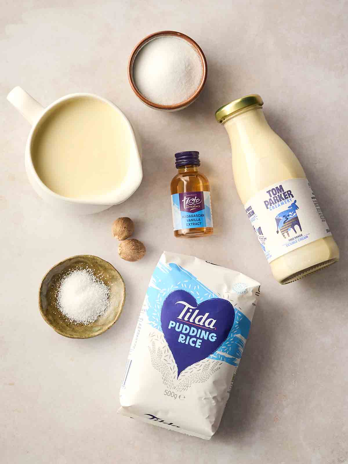 The ingredients for making slow cooker rice pudding laid out on a white counter top.