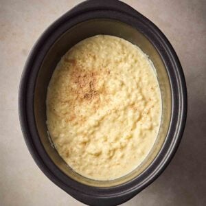 A close up of a slow cooker rice pudding, ready to eat.