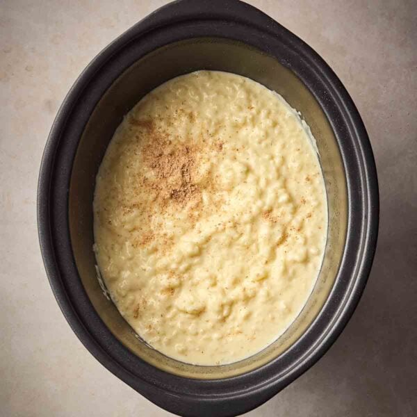 A close up of a slow cooker rice pudding, ready to eat.