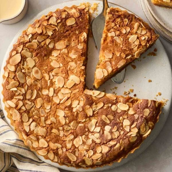 A close up of a Bakewell Tart, with a slice cut out.