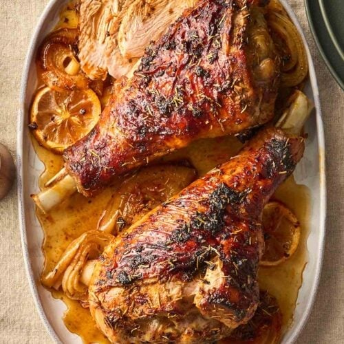 A serving platter with two roasted turkey legs on, ready to serve.